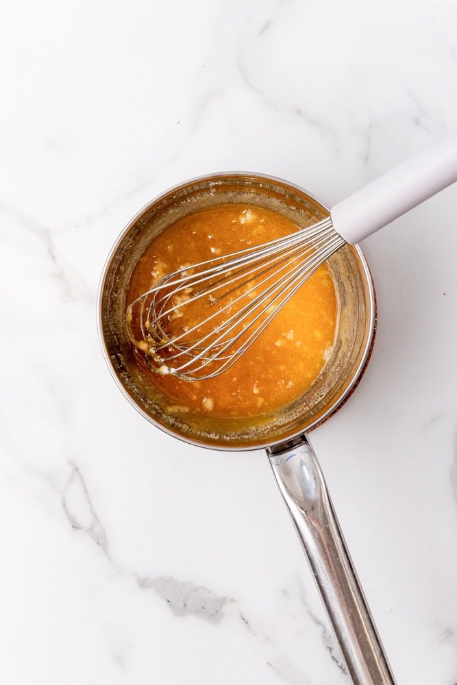 caramelized sugar in a stainless steel pan with a whisk