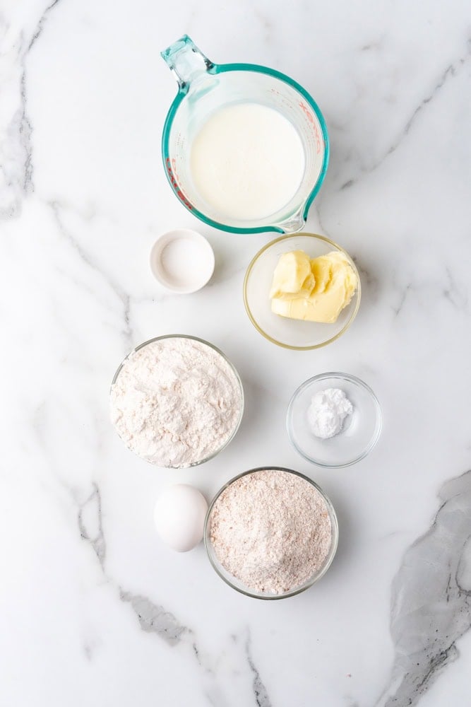 ingredients to make whole wheat biscuits, pre-measured in glass bowls.