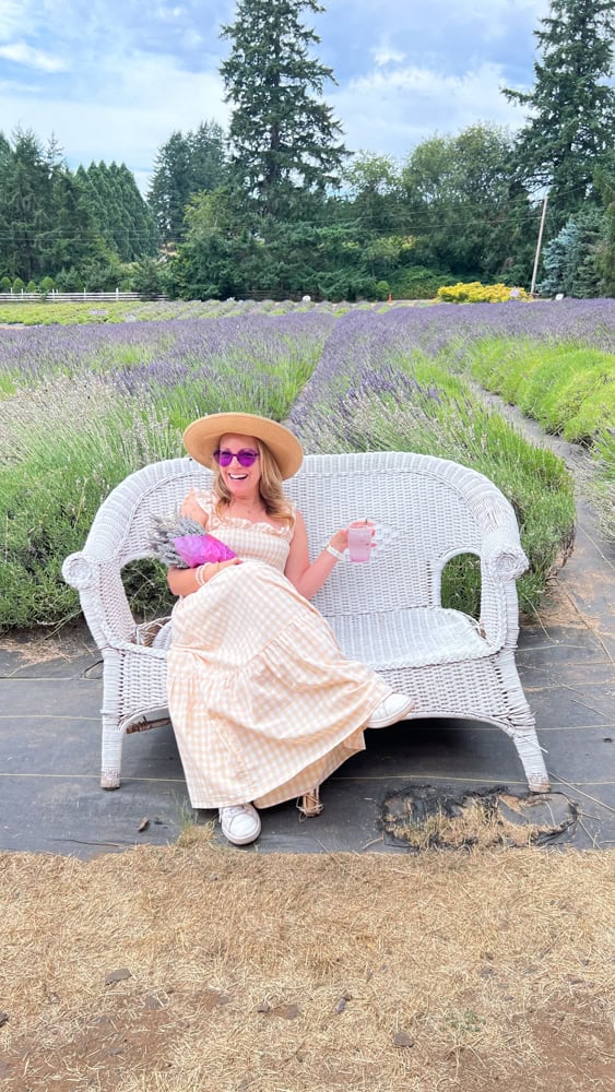 Rachelle sitting on a white wicker chair in a lavender field