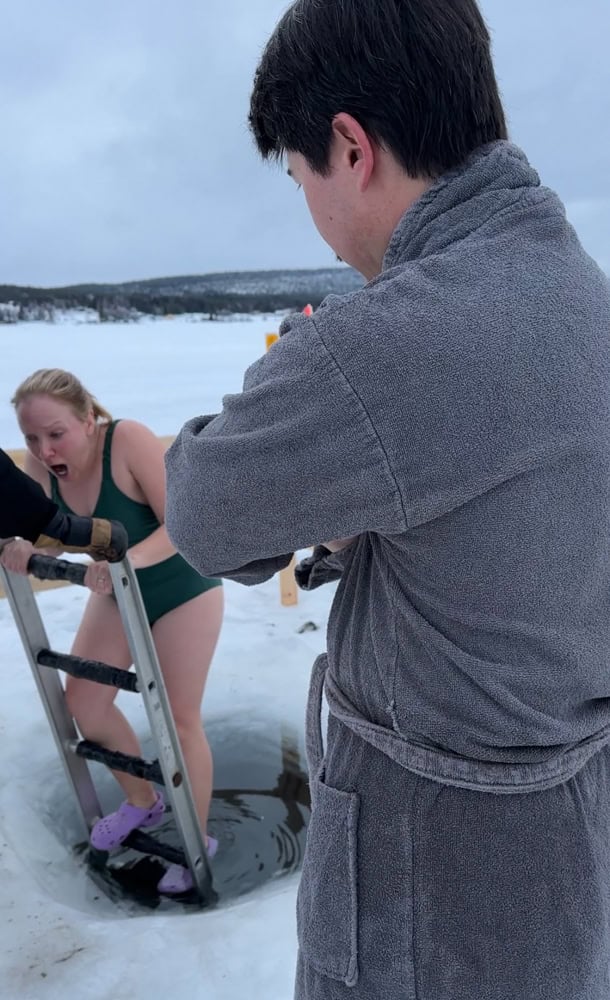 Rachelle dipping into the hole in the ice, a step in the swedish suana experience