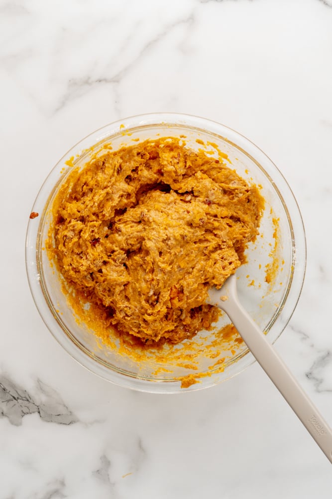 sweet potato muffin batter mixed in a glass bowl 