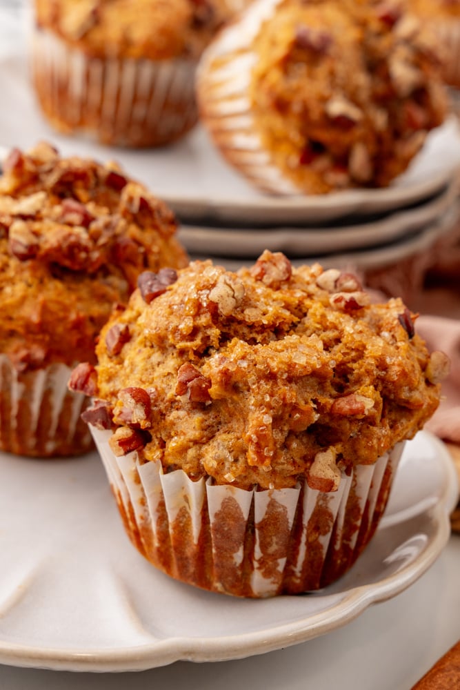 side view of sweet potato muffin showing chunky texture and crystalized sugar and pecans on top