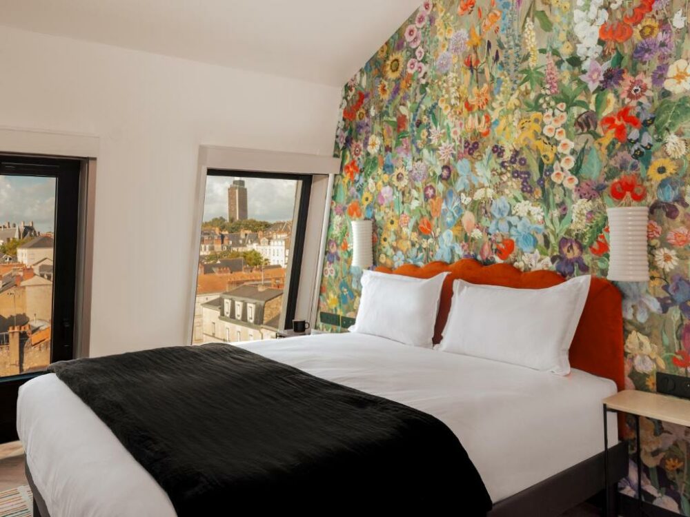 Floral wall and bed inside the Chachacha Hotel in Nantes