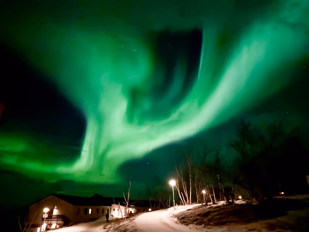 Bright green aurora over a street