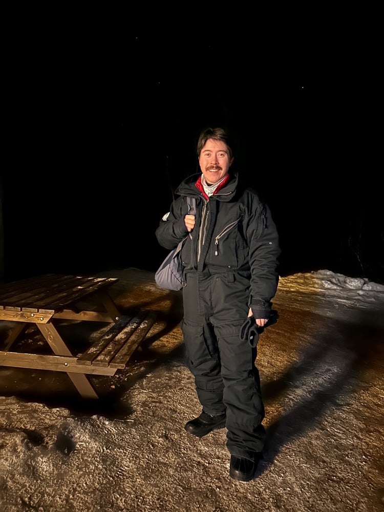 Pete wearing a black Aurora Sky Station snow suit