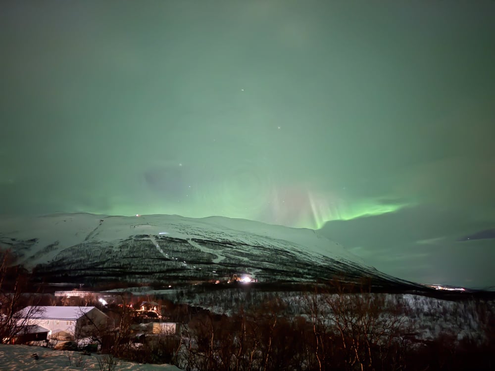 View of mountain and sky station from Abisko tourist station. There's a bit of aurora in the clouds