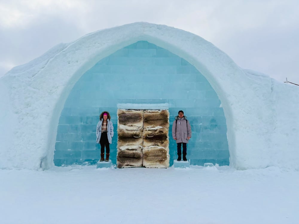 Rachelle and Pete at the entrance to the Ice hotel. It's giant, blue, and made of ice with a reindeer pelt door.