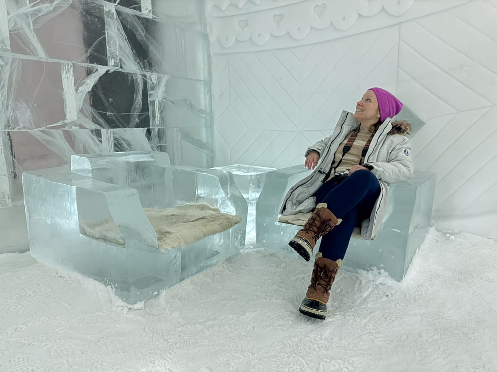 Rachelle sitting in a chair carved out of ice at the ice hotel.