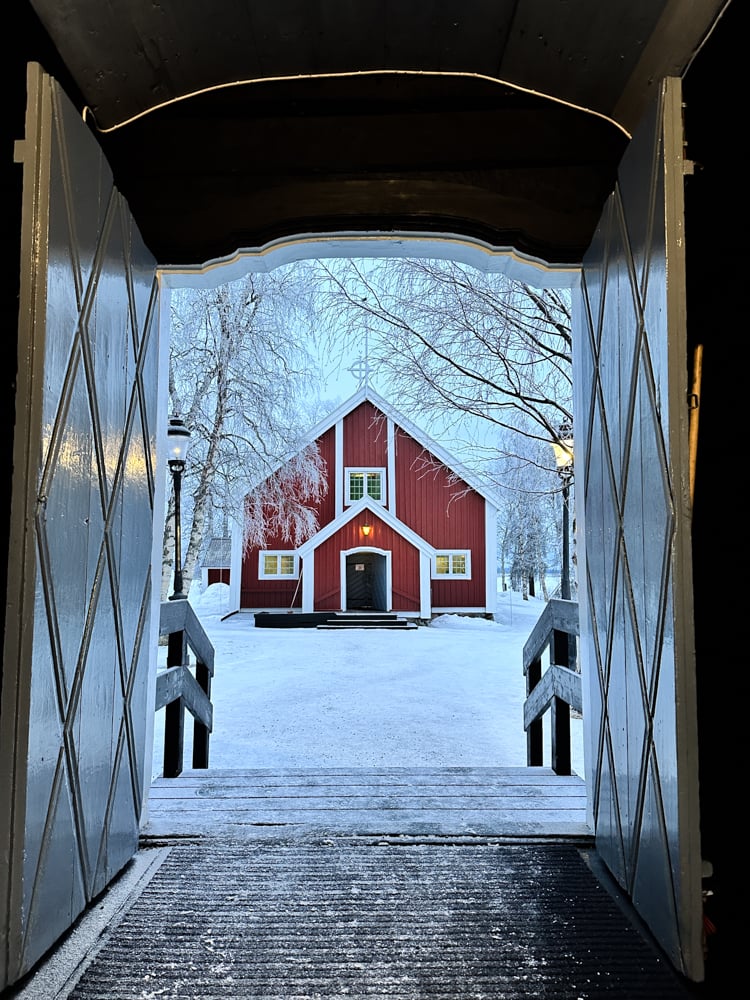 view of traditional red church building framed by doors