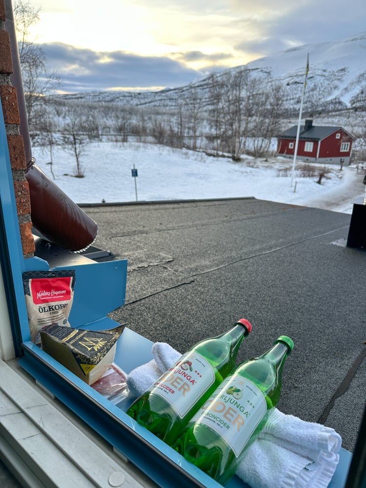 Cider and cheese outside on the windowsill keeping cold.