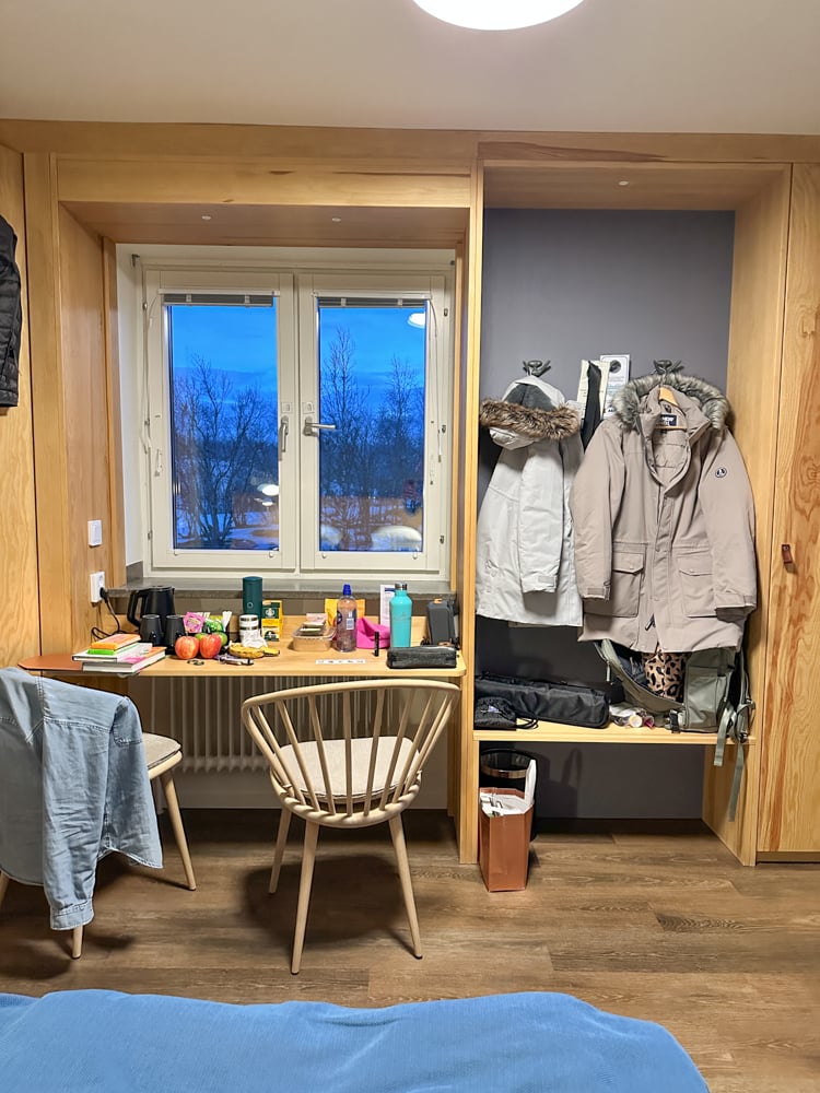 Inside of hotel room at Abisko, with parkas hung ub and snacks on a table.