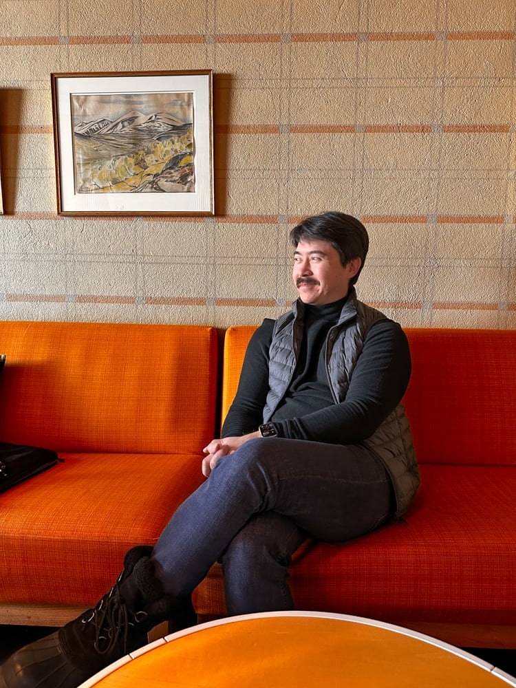 Pete sitting on an orange couch at the Absiko tourist station.