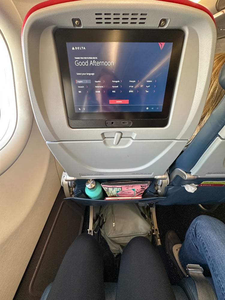 Legroom in Delta Comfort Plus. There's a water bottle and bag in the seat pocket, a backpack under the seat in front, and still plenty of leg room.