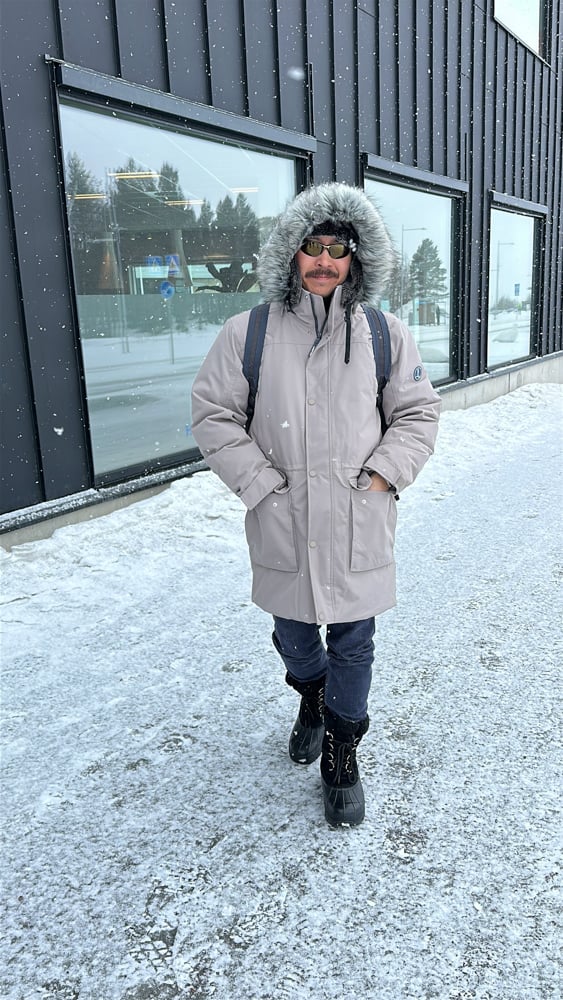 Pete wearing a parka and snow boots in the snow in Kiruna
