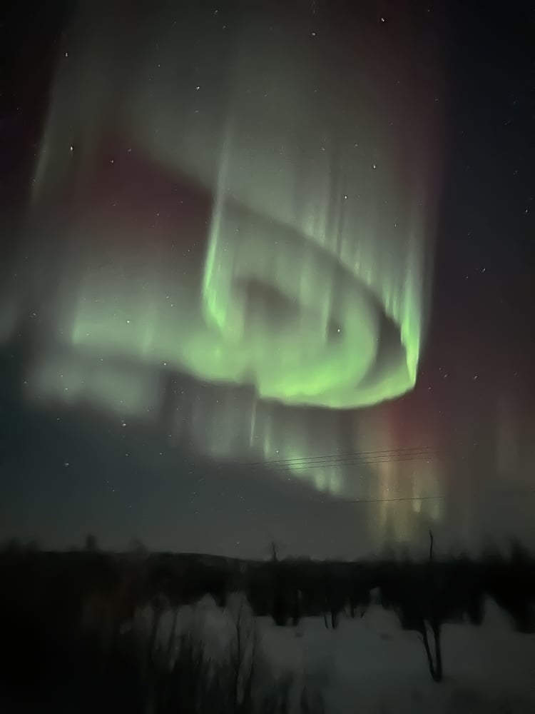 light green northern lights swirling in the sky