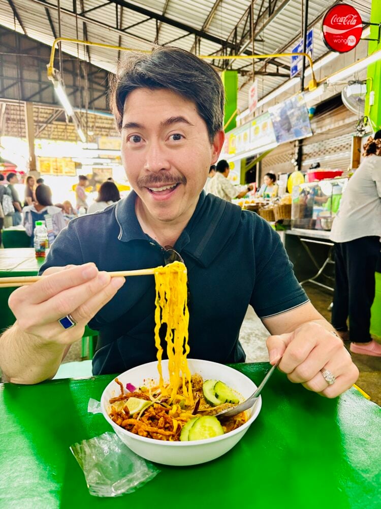 Pete smiling with a bowl of noodles