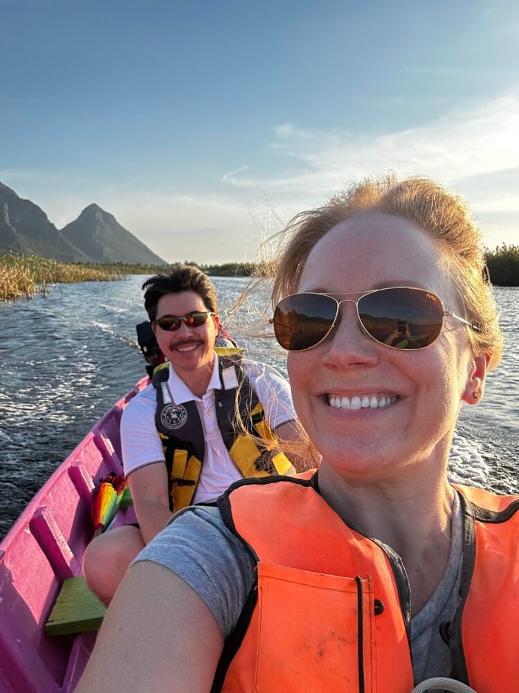 Rachelle and Pete on a boat with mountains in the background