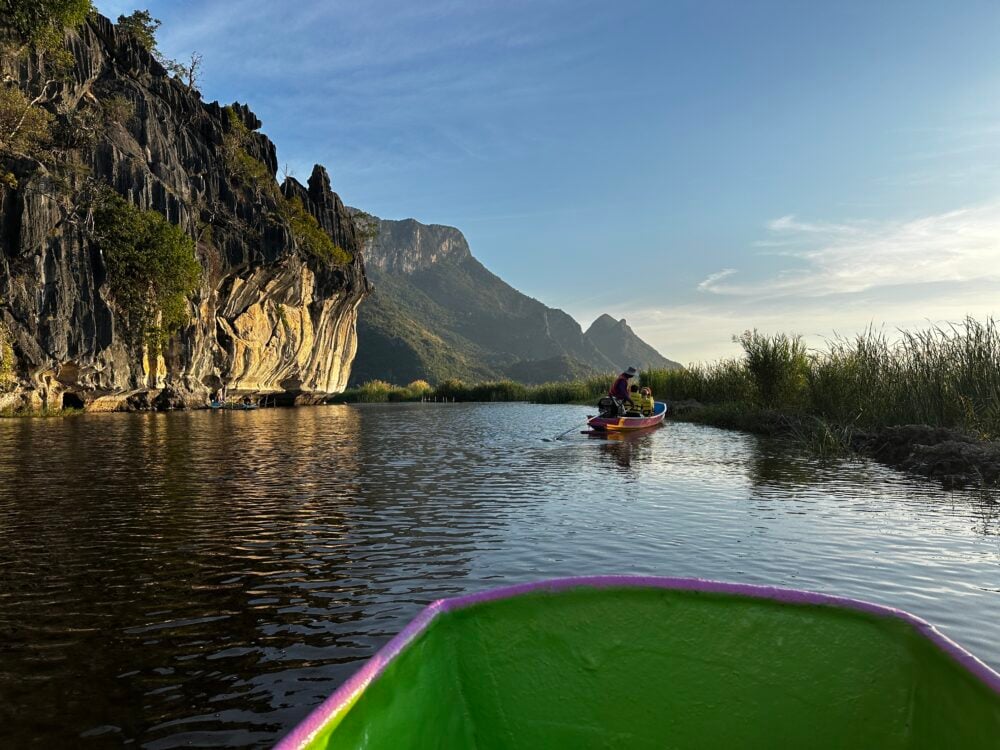Green and pink bow of boat with mountains in the background