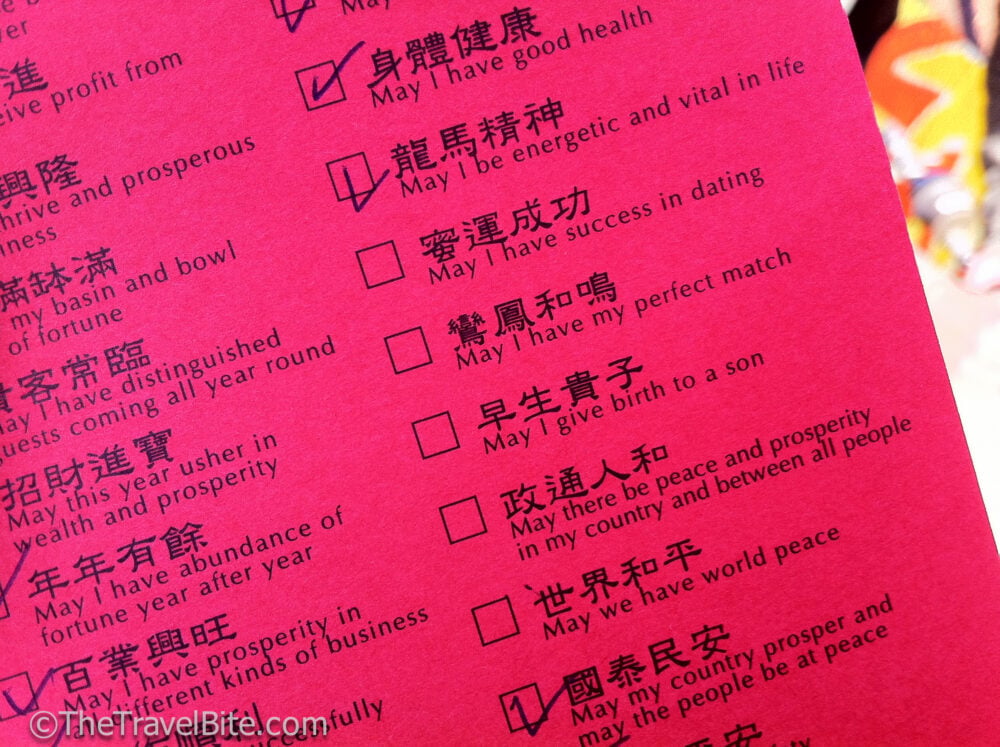 red paper with wishes written in mandarin in English where you can check boxes for your wishes