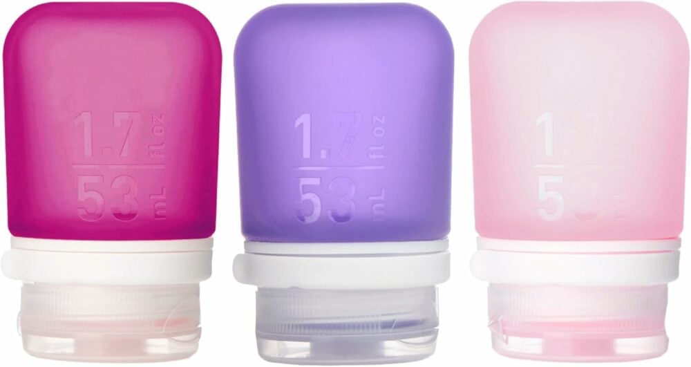 hot pink, purple, and light pink silicone travel bottles with 1.7 fl oz etched on the side.