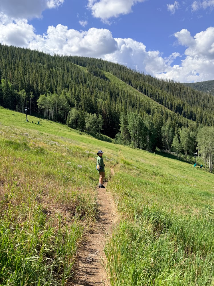 Pete hiking in Beaver Creek along a meadow into the mountains