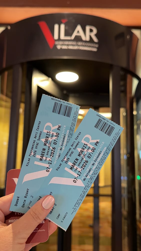 Tickets to Maren Morris held up in front of entrance of Vilar