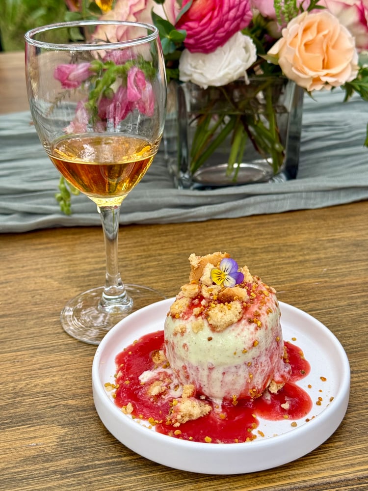 Dessert of a semi Freddo topped with a bee pollen crumble and a flower 