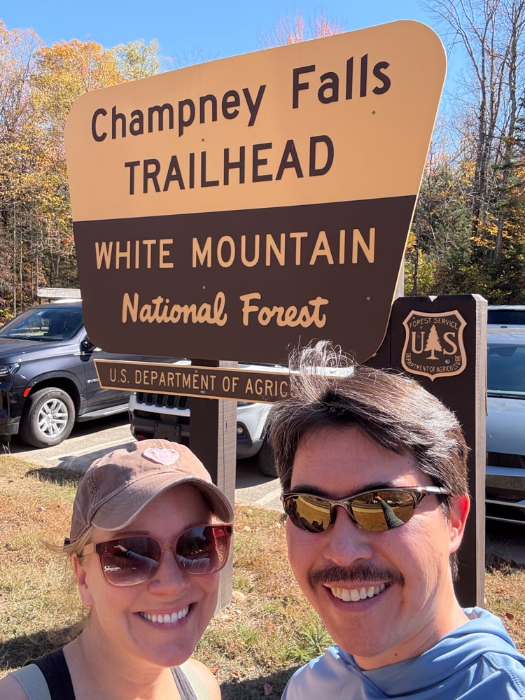 Rachelle and Pete in front of a sign for champney falls