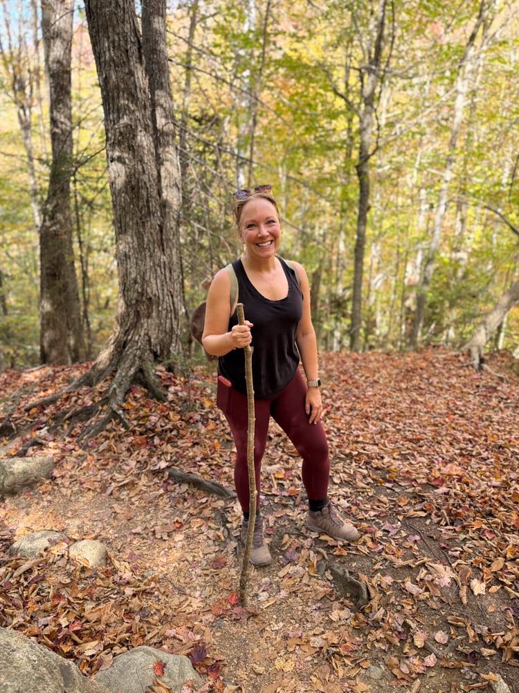 Rachelle in hiking gear with a natural walking stick