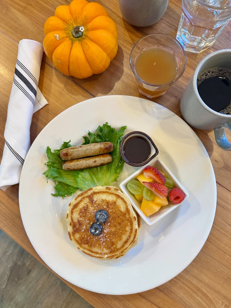 breakfast at Squam Lake Inn including pancakes, sausage, fruit, apple cider, and coffee