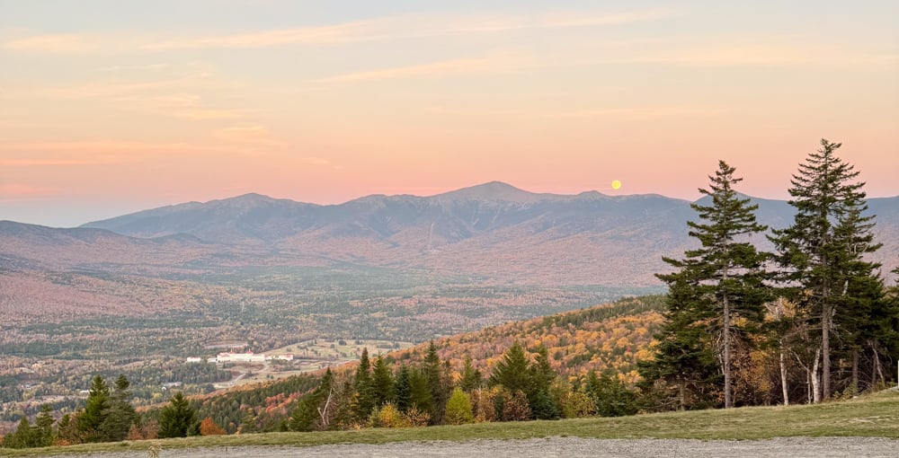 wide landscape shot that is at sunset/moonrise over Mount Washington