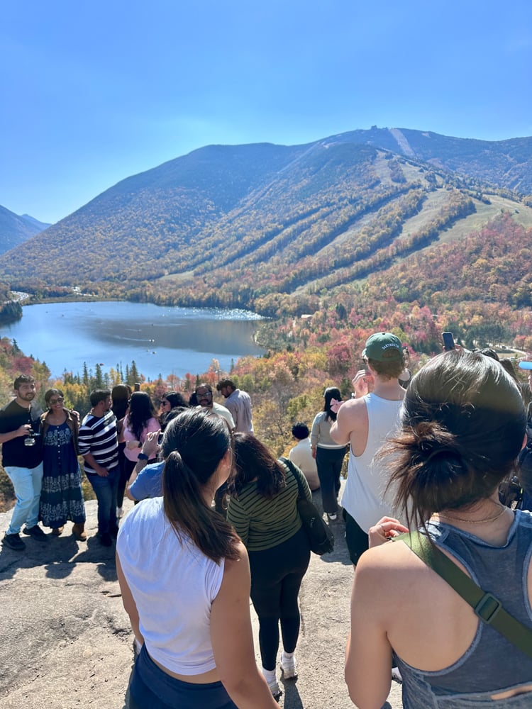 The crowd of people on the boulder looking out at the view of Artist's Bluff