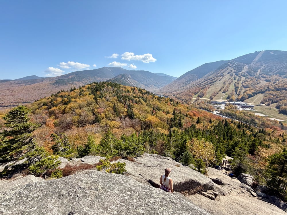rachelle leaning on a boulder and looking out at the view at Bald Mountain New Hampshire