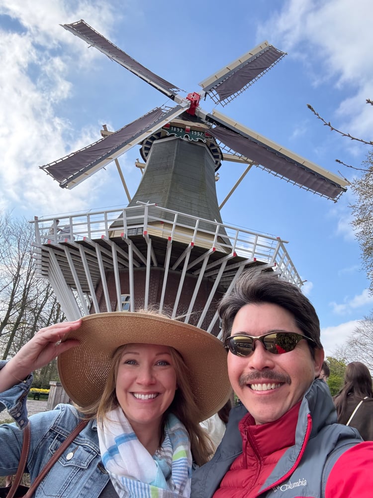 Rachelle and Pete in front of a windmill at Keukenhof Gardens in the Netherlands