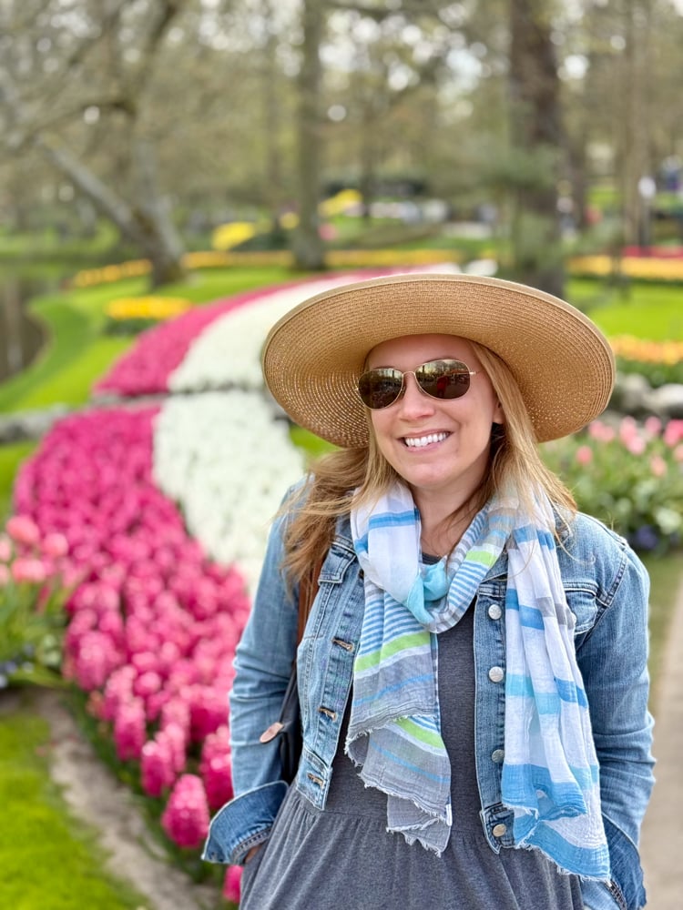 Rachelle in front of rows of pink and white flowers